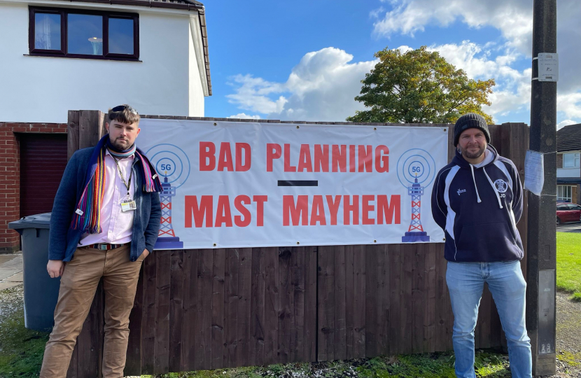 James Daly MP and Cllr Liam James Dean stand in front of the planned mast location with a "Bad Planning Mast Mayhem" sign