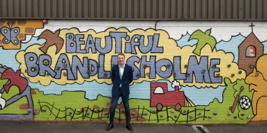 Cllr Rydeheard at the 'Beautiful Brandlesholme' climbing wall in the playground at Woodbank Primary School